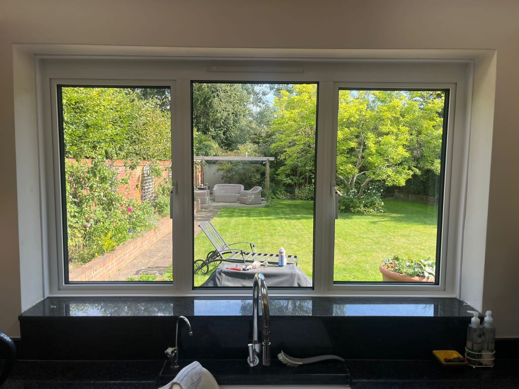 Large three pane aluminium window in kitchen with sink below