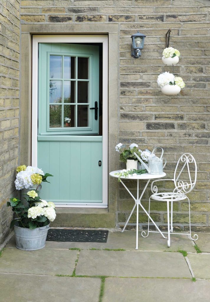 stable door fitted with double glazing dorking with small white table and chairs outside