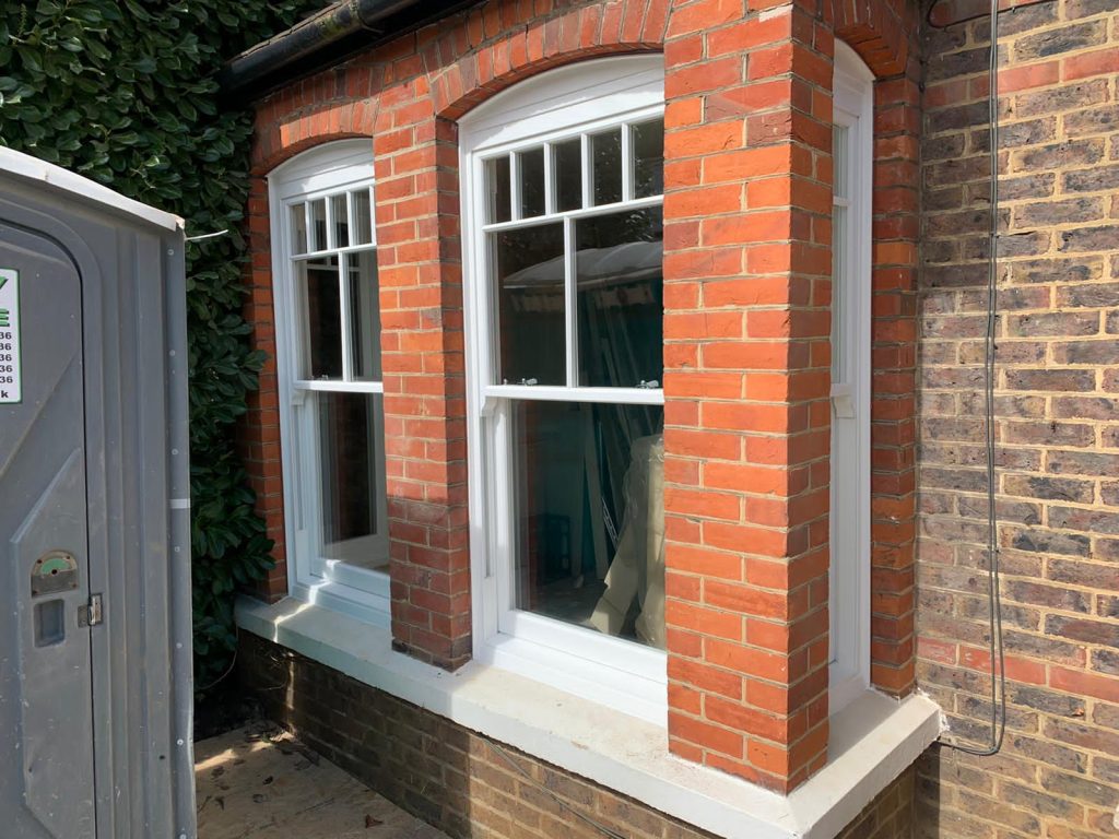 sash windows in modern home with brick pillars