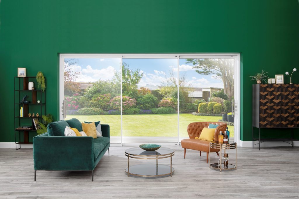 An Origin sliding door with three panels set into a green wall.