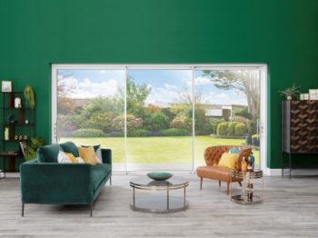 An Origin sliding door with three panels set into a green wall.